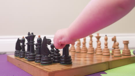 baby's hands moving chess pieces