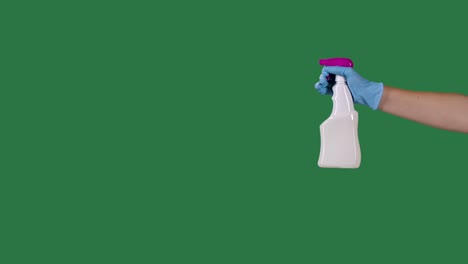 man in protective gloves sprays a cleaning hygienic spray for disinfection and prevention of covid 19. green screen, chroma key. slow motion. close up