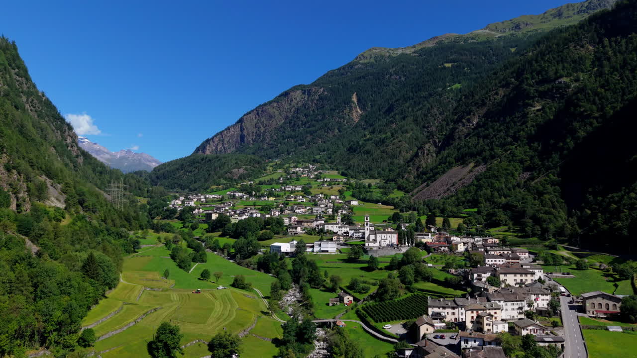 Scenic Swiss village nestled in lush valley under clear blue skies