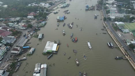 Boats-motor-up-and-down-river-past-floating-market-in-Can-Tho,-Vietnam