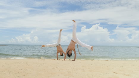 Dos-Hombres-Bailando-Capoeira-En-La-Playa