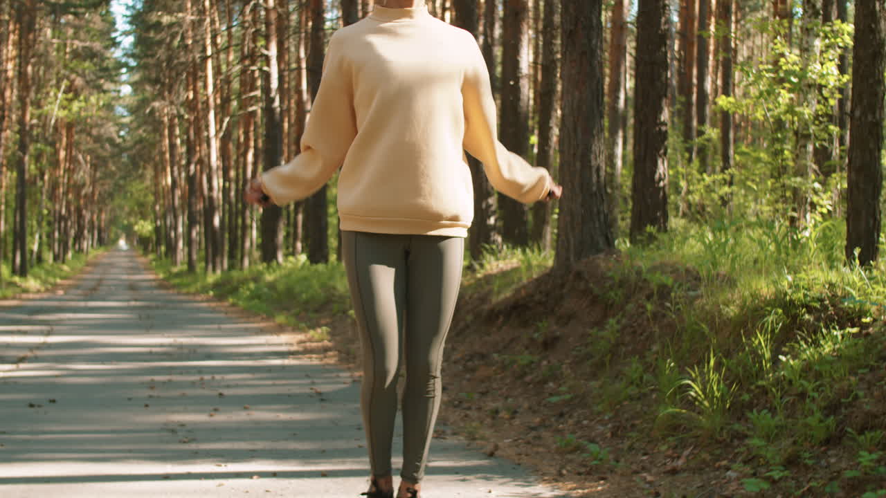 Frau beim Seilspringen auf einem Waldweg