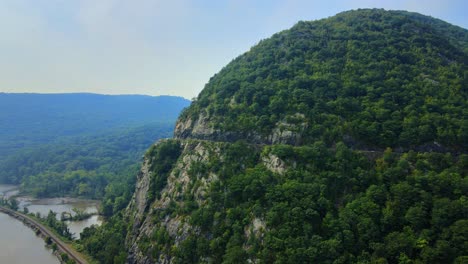 aerial drone video footage of an appalachian mountain river valley with a beautiful domed mountain with a road