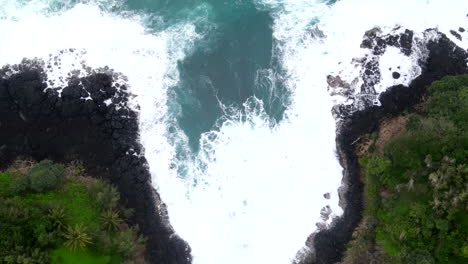 Aerial-Top-Down-View-of-Waves-Crashing-into-Cliffs-of-Princeville,-HI