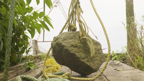 , una piedra de red china utilizada para pescar en aguas estancadas ,una piedra que cuelga de una red china