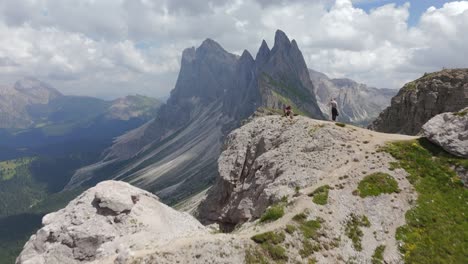 stunning aerial footage of seceda mountain ridge in the dolomites, italy, featuring hikers on rocky terrain and breathtaking alpine views