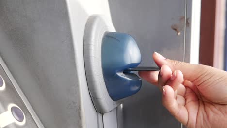 person inserting credit card into atm