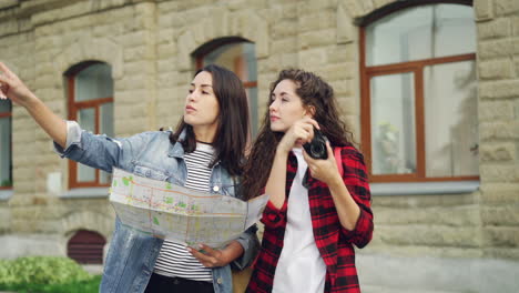 two friends exploring a city using a map and camera