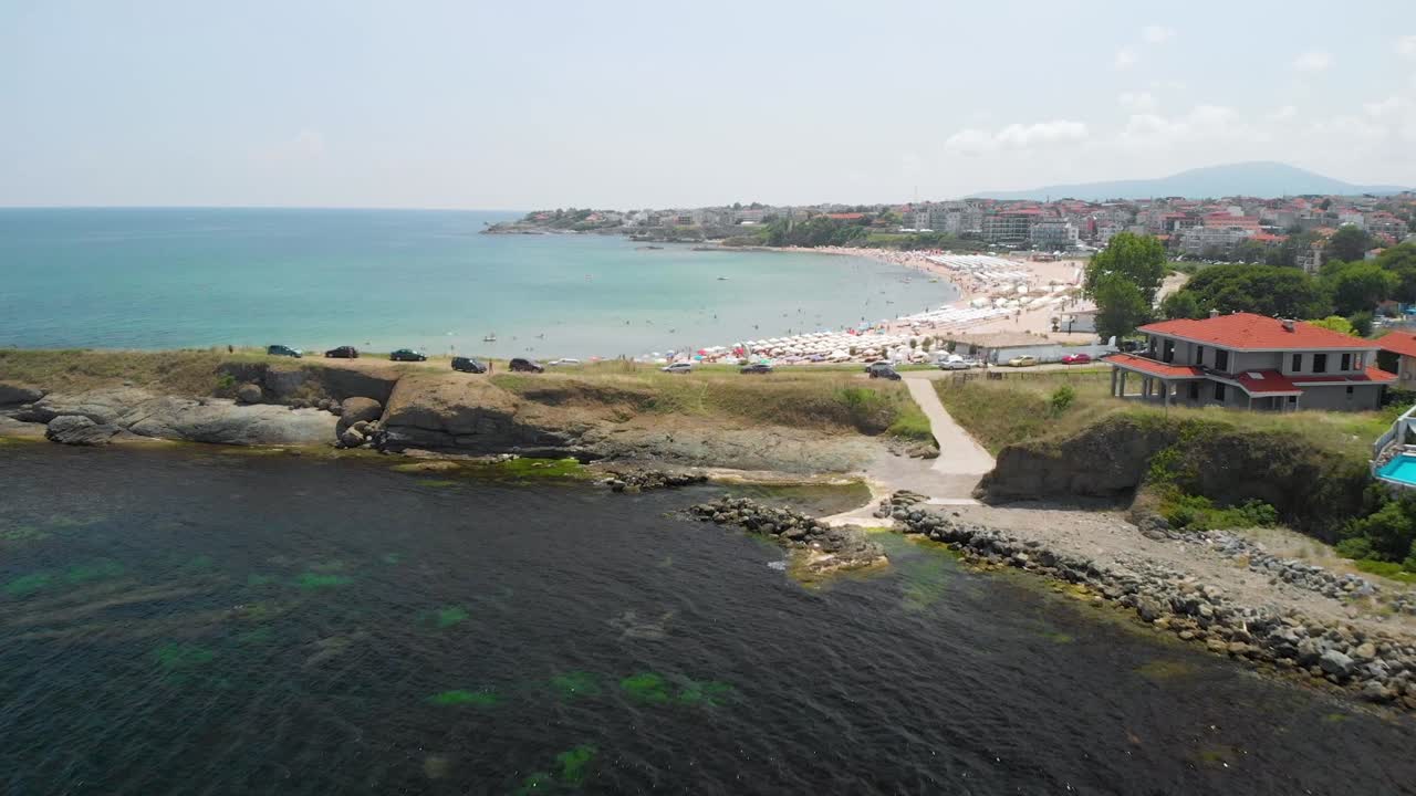 vuelo rápido de drones sobre la costa rocosa y los edificios en un día soleado de verano