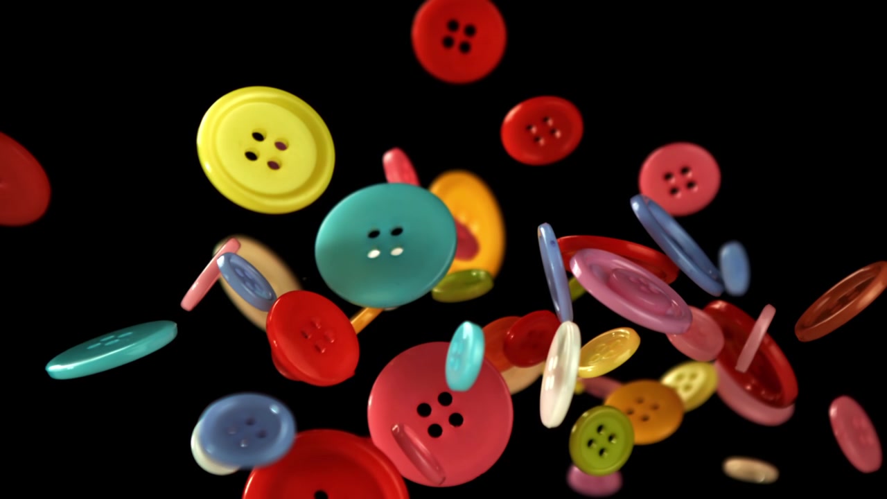 Bottoni da cucito colorati che cadono al rallentatore su sfondo nero.
