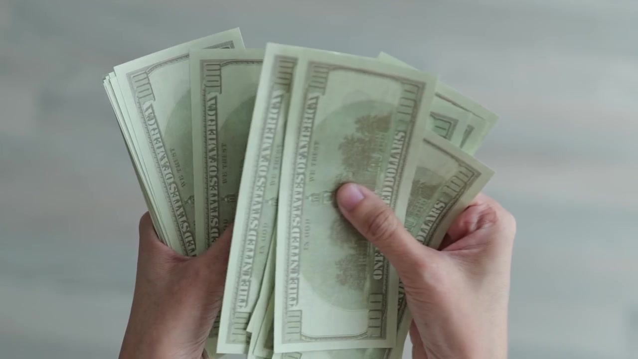 Primo piano di mani che contano banconote, evidenziando la gestione del contante, la finanza personale, il budgeting e la gestione quotidiana del denaro.