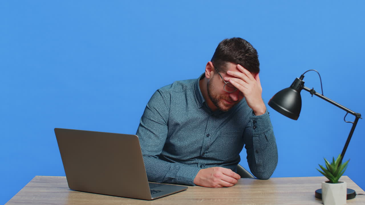 Man using laptop surprised by bad news fortune loss game fail lottery results sitting at table