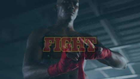 animation of fight text against young african man wrapping hand with sports bandage at gym