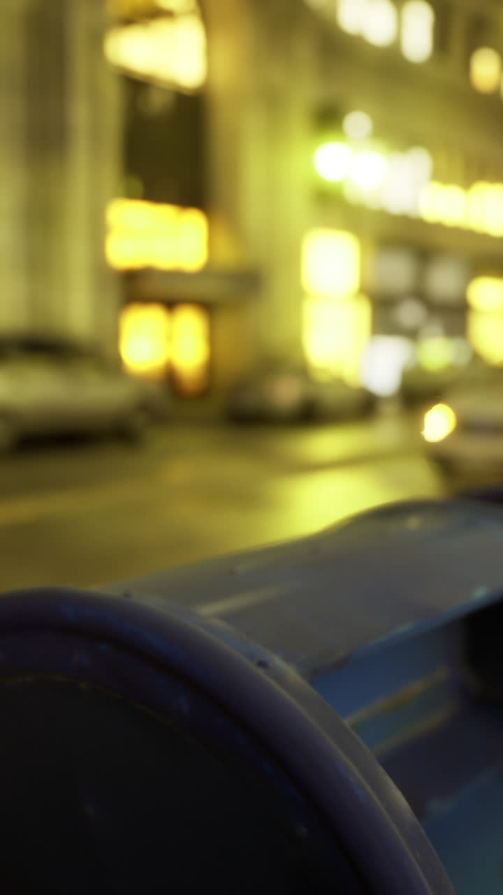 Evening urban street illuminated by city lights with mailboxes in focus