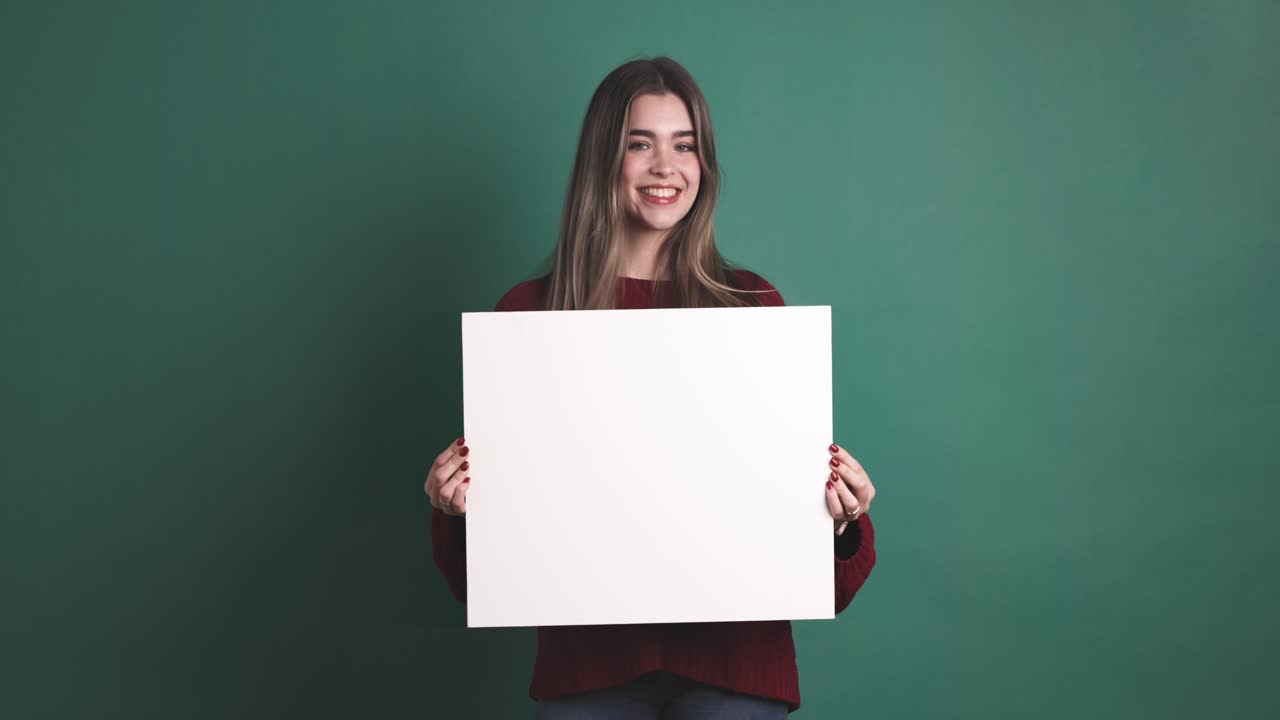 Woman holding a blank panel while smiling at the camera