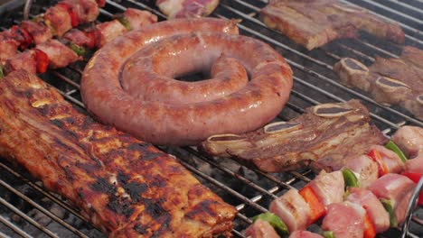 traditional spanish barbeque, big sausage chorizo botifarra, pork and beef ribs on grill with fire, american style cooking, chef grilling meat fat food, steaks and sausages on bbq. high quality 4k footage