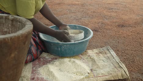 Woman-Sifting-Cassava-Flour.-Side-Medium-Shot