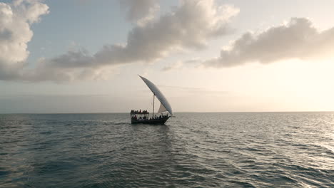 summer concept, dhow boat sails in the ocean at sunset, zanzibar, tanzania