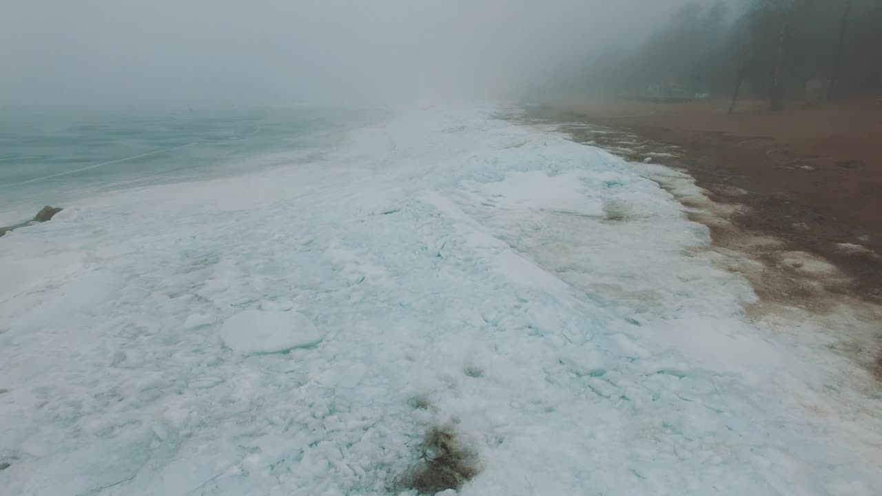 얼어붙은 바다 해안선 위를 날아다니며 안개와 추운 겨울의 날