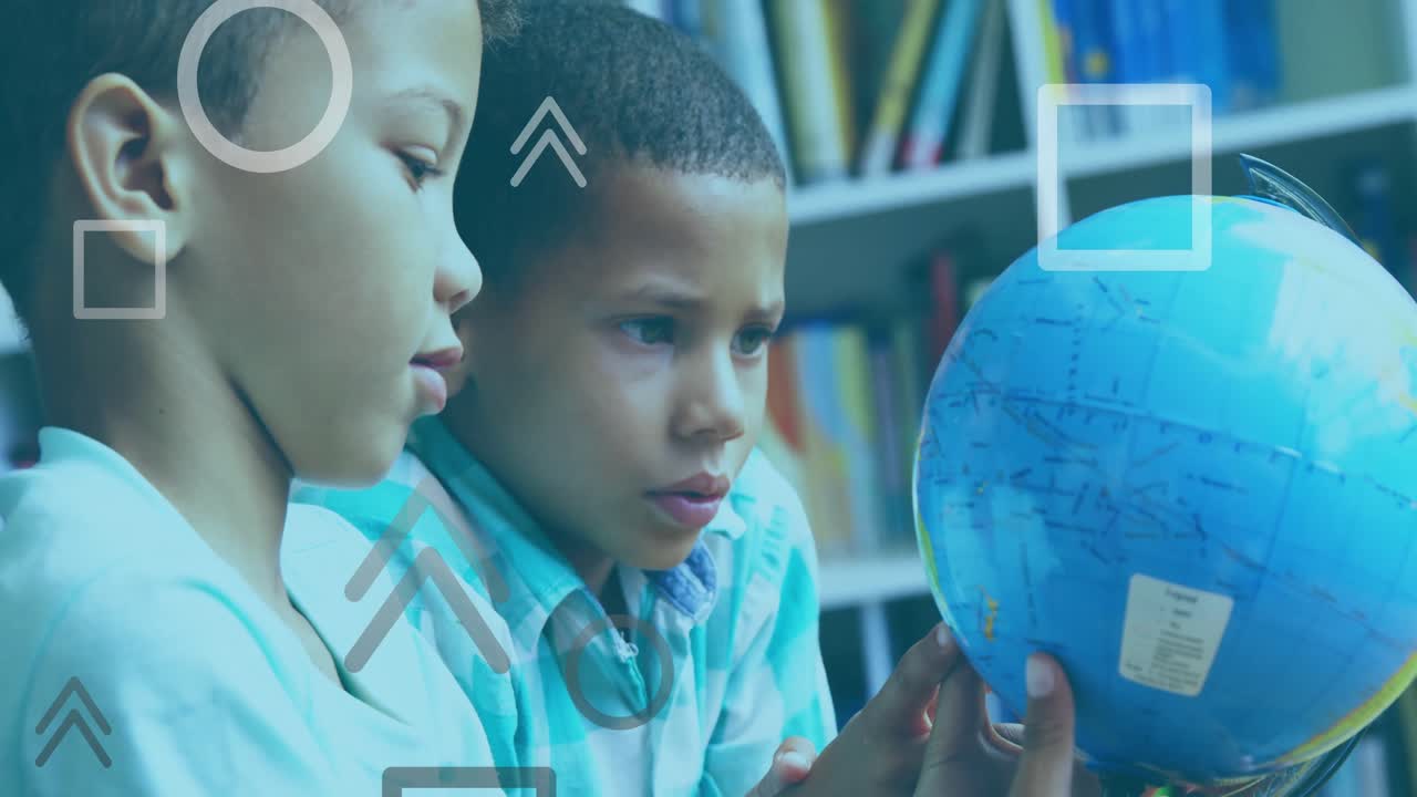Two student boys spinning globe in library pointing South America, nodding and studying geography