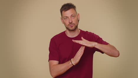 time out, need a break, tired serious upset handsome young man showing pause relax gesture, stop