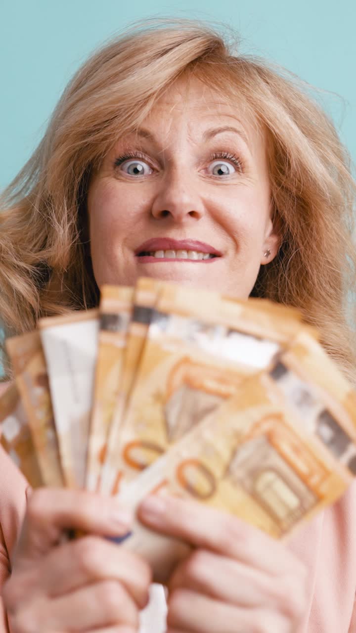 Opgewonden blonde vrouw houdt en toont eurobiljetten
