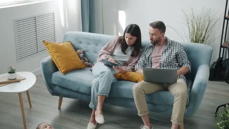 family using technology together on the couch
