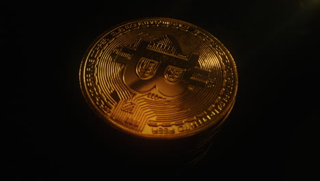 oro de bitcoin girando contra un fondo negro - toma de ángulo alto