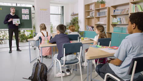 Profesor-Enseña-A-Un-Grupo-De-Estudiantes-Multiétnicos-Las-Palabras-&#39;bajo&#39;-Y-&#39;alto&#39;-En-El-Aula-De-Inglés