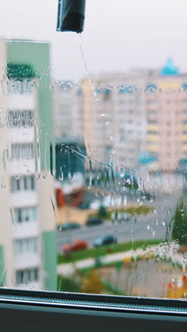 water cleaner with wet glass. close up view of cleaning wet window. vertical video