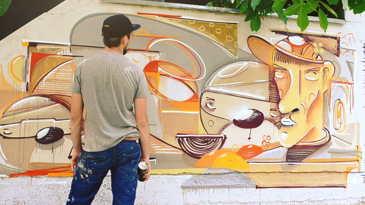 L'artista disegna graffiti su una recinzione. Graffiti su una recinzione.