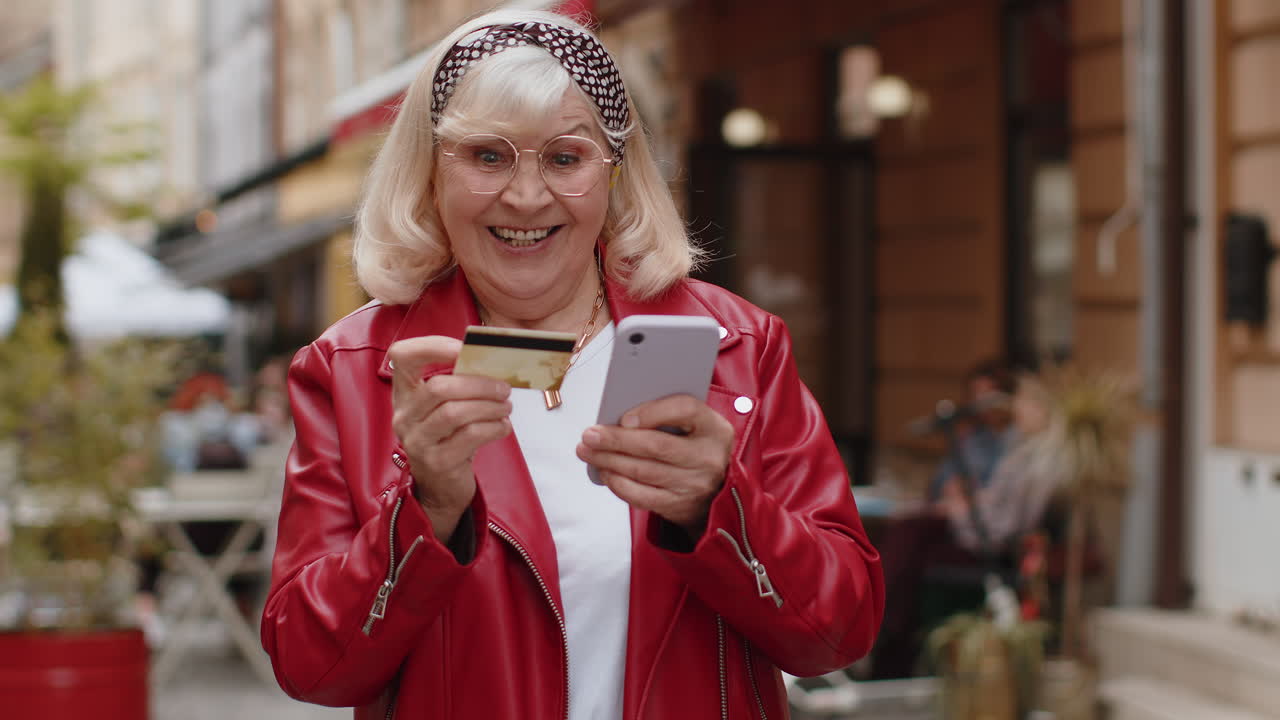 Mulher idosa usando smartphone de cartão de crédito enquanto transfere dinheiro para compras on-line