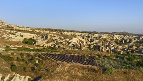 Göreme-Turkey-Aerial-v68-panoramic-sunrise-landscape-view,-drone-fly-around-plateau-field-capturing-spectacular-rock-formations-and-hot-air-balloons-in-the-sky---Shot-with-Mavic-3-Cine---July-2022