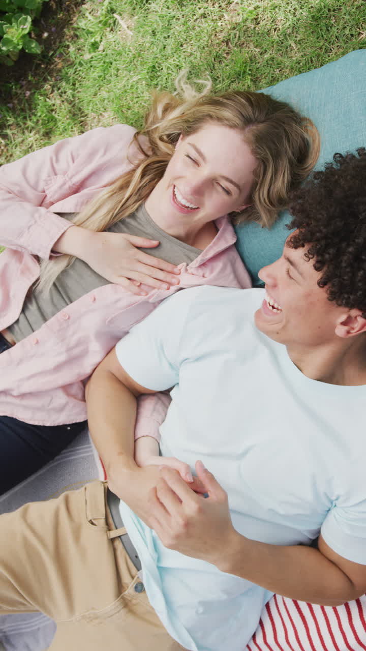 다양한 커플이 미소 짓고 잔디에 매트에 누워있는 수직 비디오