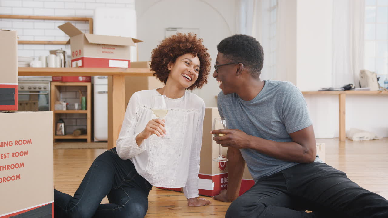 retrato de una pareja celebrando su mudanza a una nueva casa con un vaso de vino
