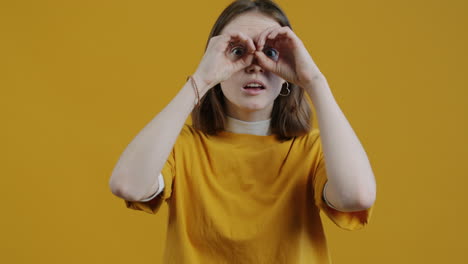 young woman with hands to face, yellow background