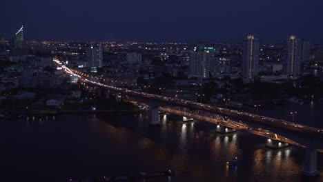 Huge-bridge-over-the-Chao-Phraya-river-in-Bangkok-city-at-night,-Thailand
