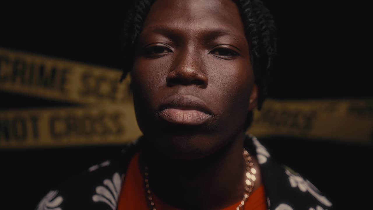 Portrait of Serious Black Man Posing at Crime Scene during Night