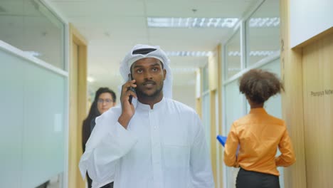 businessman talking on phone in office corridor