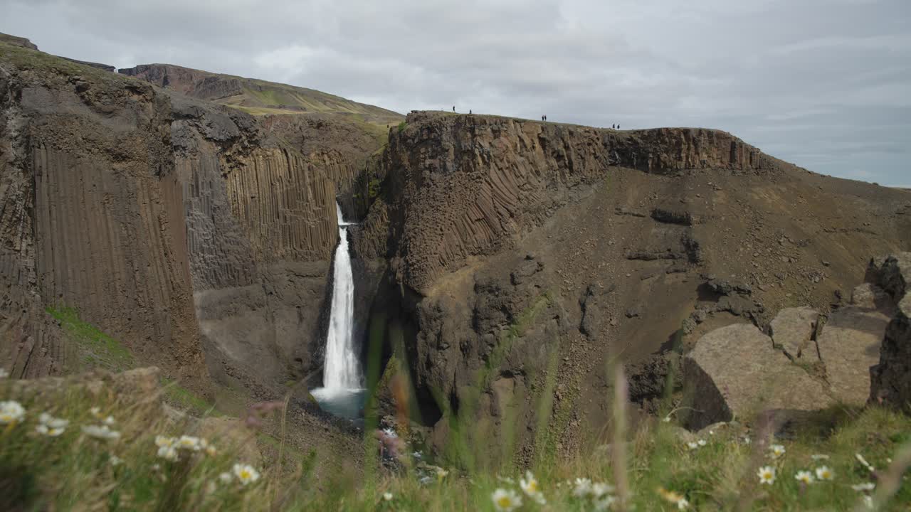 turistas que visitan la majestuosa cascada de litlanesfoss en islandia en un día tranquilo