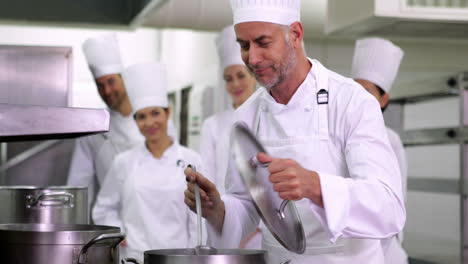 Jefe-De-Cocina-Degustando-Una-Olla-De-Sopa-Haciendo-El-Cartel-De-Ok