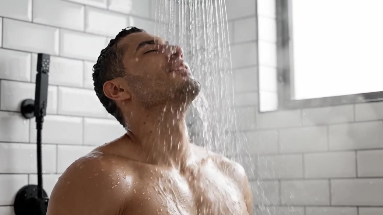 A Man Enjoying a Refreshing Shower Experience, Capturing Moments of Relaxation and Self-Care Under Cascading Water in a Modern Bathroom Environment