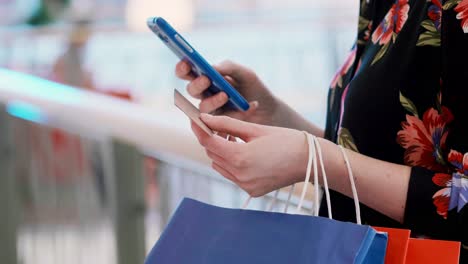 chica usando teléfono móvil y tarjeta de crédito durante las compras en línea