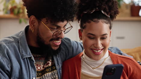 pareja mirando un teléfono y riendo juntos