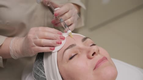 a patient reclines while receiving a facial injection from a clinician in a medical spa setting, highlighting aesthetic treatment without focusing on specific brand names