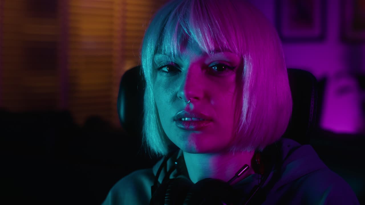 retrato de una joven mujer caucásica con auriculares frente a una computadora de escritorio