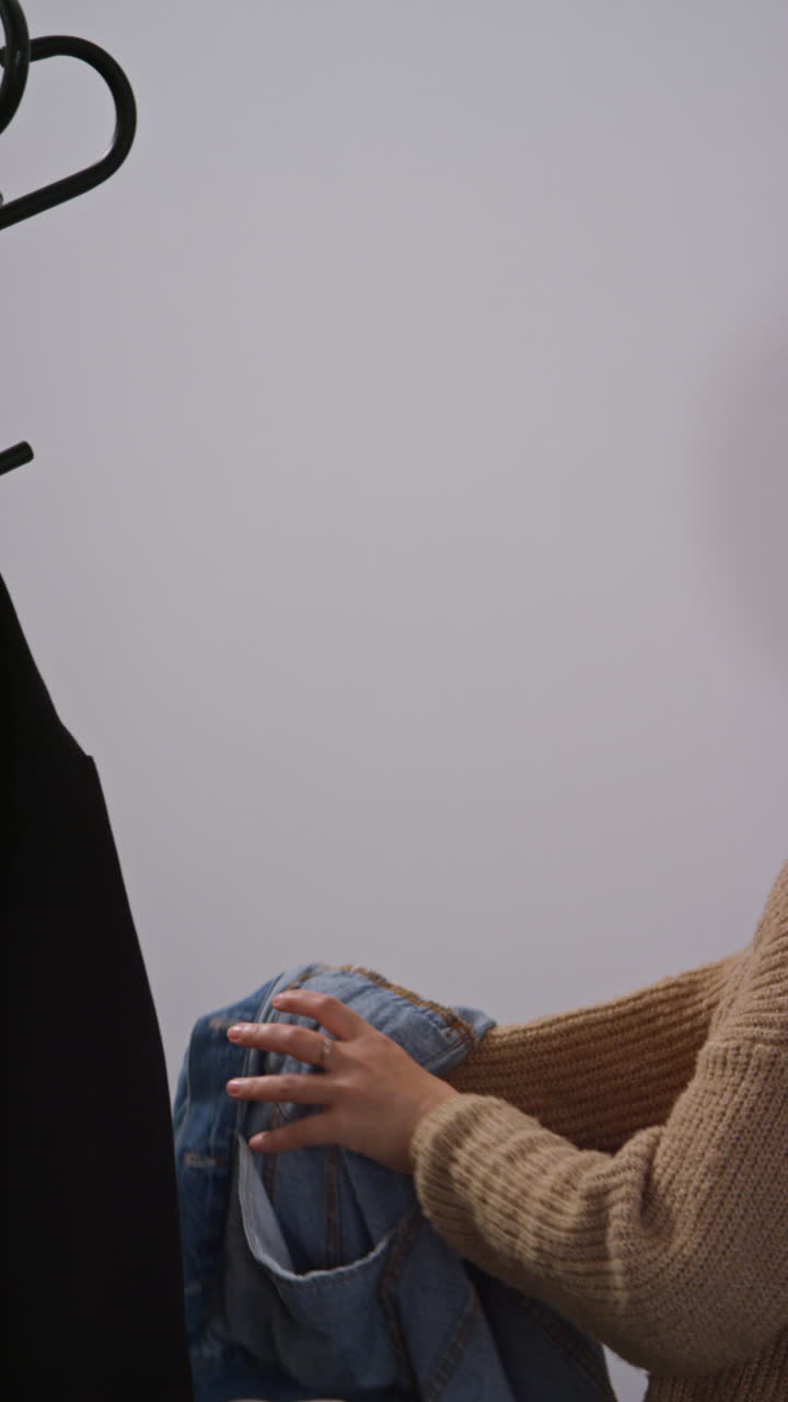 Vertical Video Of Woman Getting Home From Food Shopping Hanging Up Coat And Carrying Bag Of Fresh Vegetables Indoors Into Kitchen