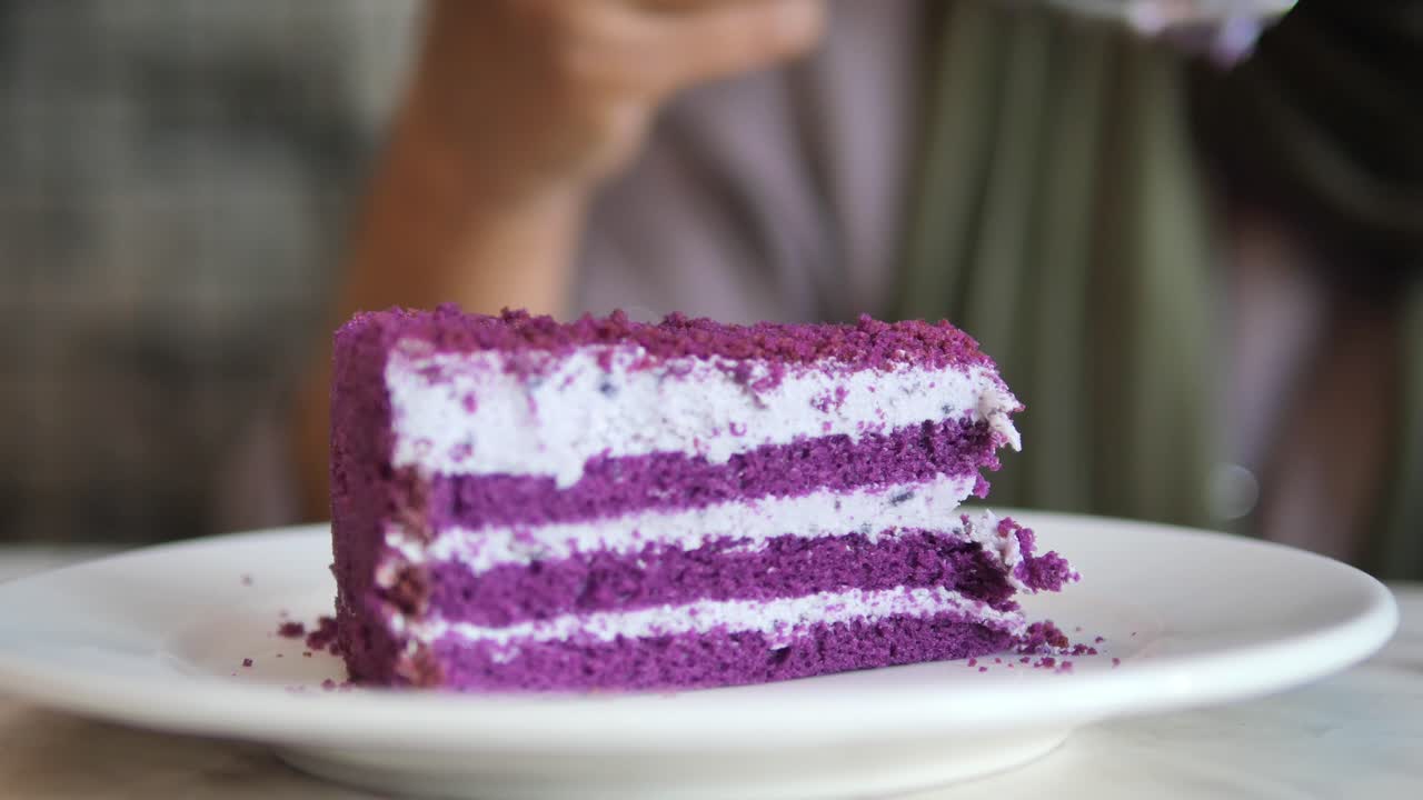 Donna che mangia una torta viola