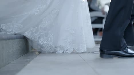 Bride's-dress-drags-across-the-floor-as-she-walks-down-stairs-towards-wedding-ceremony-location