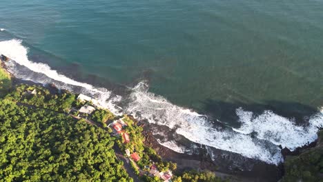 aerial shot of ocean waves crashing the coastline, el tunco beach in el salvador, tourism and surfing